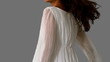 Girl in white dress twirling on grey background close up
