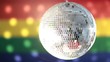 Disco ball spinning against rainbow flag