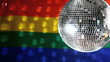 Disco ball revolving against gay pride flag