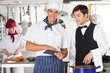 Chef With Waiter Using Digital Tablet