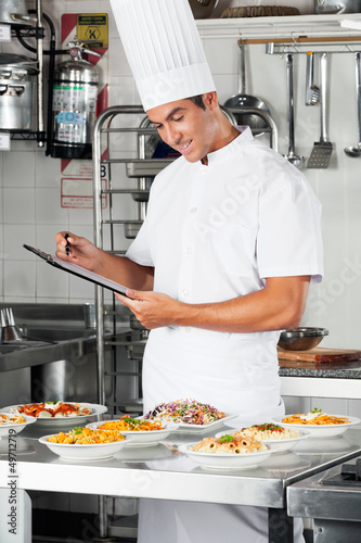 Photo: Young Chef With Clipboard At Kitchen Young Chef With Clipboard At Kitchen
