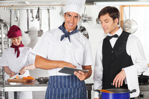 Photo: Chef With Waiter Using Digital Tablet Chef With Waiter Using Digital Tablet