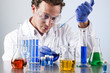 chemist working at a lab bench with various solutions