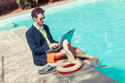 Photo: Funny Young Businessman with SwimmingTrunks next to the Pool Funny Young Businessman with SwimmingTrunks next to the Pool