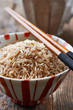 Bowl of  brown rice with chopsticks