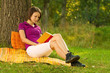 Beautiful young brunette reading in the park