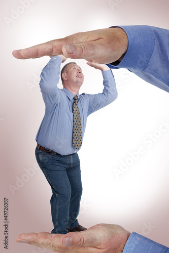 Photo: Man is under pressure between two hands Man is under pressure between two hands