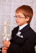 boy with candle in day of the first holy communion
