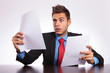 surprised man reads letter at desk