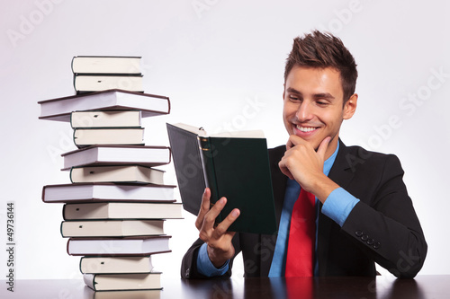 Photo: man at desk reading book man at desk reading book