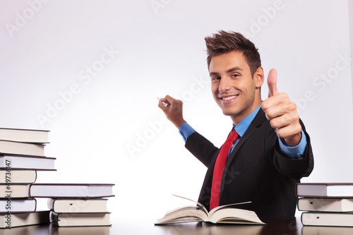 Photo: at desk writing & thumb up at desk writing & thumb up