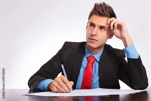 Photo: man at desk thinking what to write man at desk thinking what to write