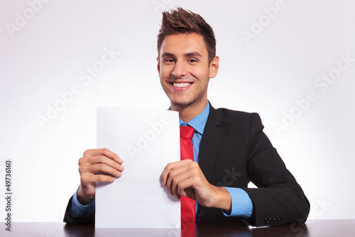 Photo: man at desk showing some papers man at desk showing some papers