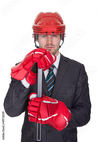 Photo: Competitive businessman wearing hockey equipment Competitive businessman wearing hockey equipment