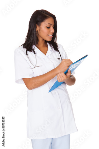 Photo: Female Doctor Writing On Clipboard Female Doctor Writing On Clipboard