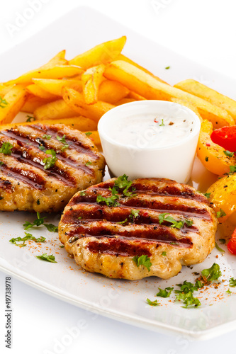 Photo: Grilled steaks, French fries and vegetables Grilled steaks, French fries and vegetables