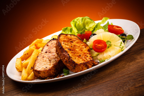 Photo: Grilled steaks, French fries and vegetables Grilled steaks, French fries and vegetables