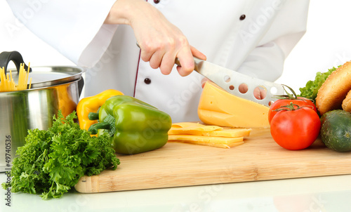 Photo: Female hands cutting cheese, isolated on white Female hands cutting cheese, isolated on white
