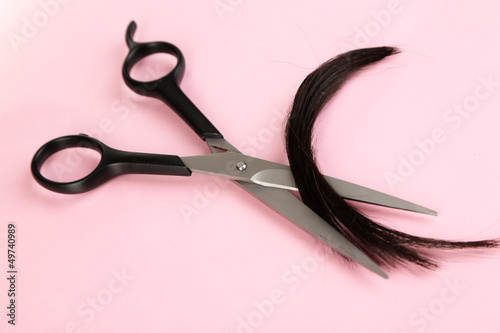 Photo: Pieces of hair cut with scissors on pink background Pieces of hair cut with scissors on pink background