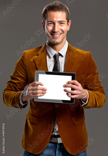 Photo: Young businessman showing a tablet screen. Young businessman showing a tablet screen.