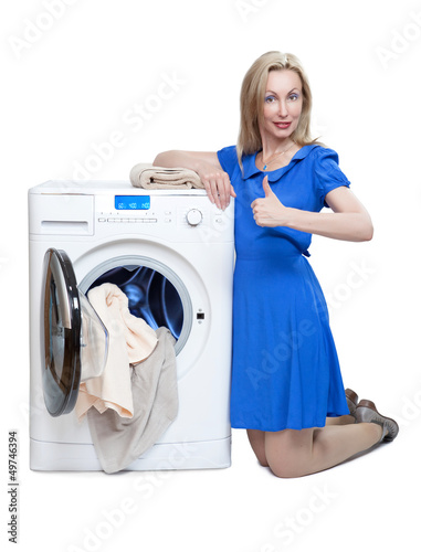 Photo: The happy young woman near the new washing machine The happy young woman near the new washing machine