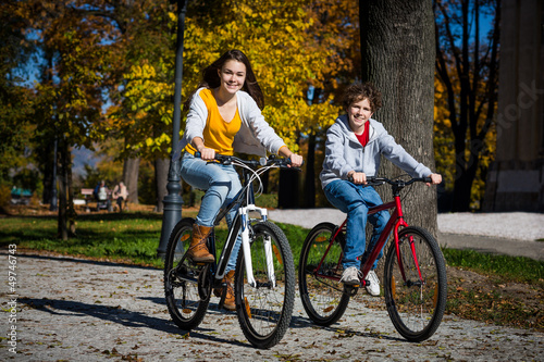 Photo: Urban biking - teens riding bikes in city Urban biking - teens riding bikes in city