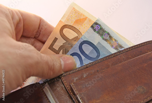 Photo: hand that pays taking the euro money from wallet hand that pays taking the euro money from wallet