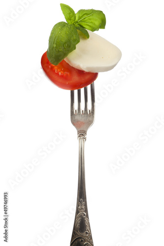 Photo: Caprese salad on silver fork isolated Caprese salad on silver fork isolated