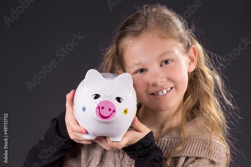 Photo: Mädchen zeigt stolz ihr Sparschwein Mädchen zeigt stolz ihr Sparschwein