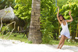 Photo: young beautiful woman swinging on natural background young beautiful woman swinging on natural background