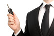Isolated businessman in suit holding a car key