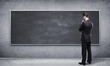 man looking at blackboard