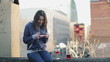 Young woman drinking wine and using smartphone on terrace