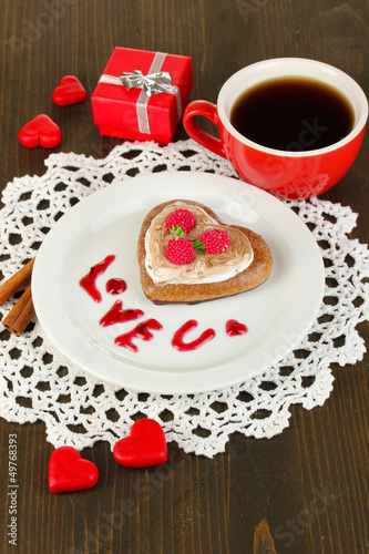 Photo: Chocolate cookie in form of heart with cup of coffee Chocolate cookie in form of heart with cup of coffee