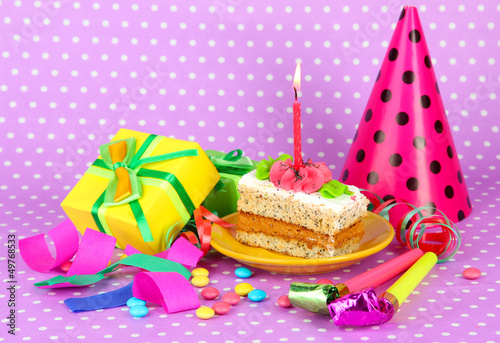 Photo: Colorful birthday cake with candle and gifts on pink background Colorful birthday cake with candle and gifts on pink background