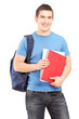 Smiling male student with backpack holding books