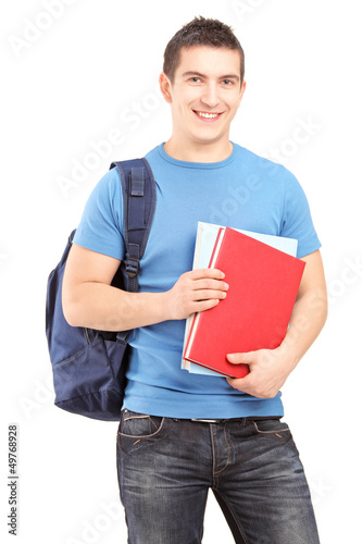 Photo: Smiling male student with backpack holding books Smiling male student with backpack holding books