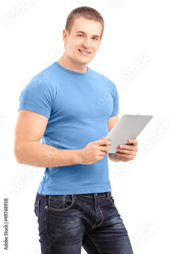 Photo: Young man holding a tablet and looking at camera Young man holding a tablet and looking at camera