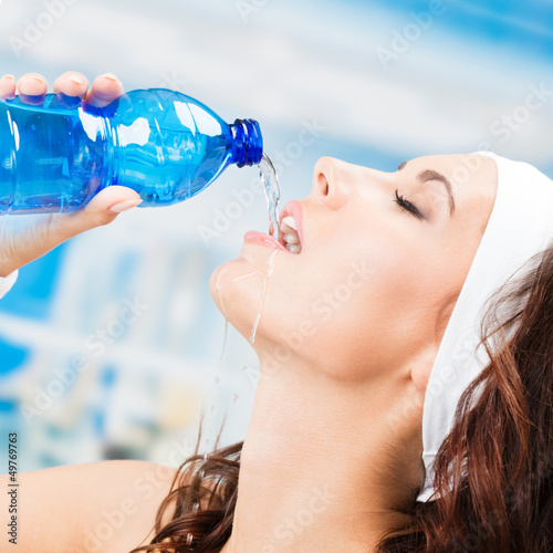Photo: Woman drinking water, at fitness club Woman drinking water, at fitness club