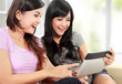 women friends at home using tablet computer