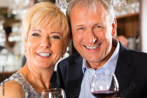 Photo: Senior couple at bar with glass of wine in hand Senior couple at bar with glass of wine in hand