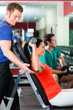 woman and Personal Trainer in gym, with dumbbells