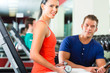 woman and Personal Trainer in gym, with dumbbells