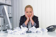 Frau im Büro mit zerknülltem Papier