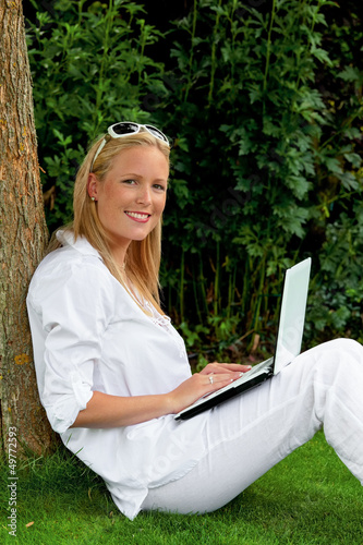 Photo: Frau mit Laptop Computer im Garten Frau mit Laptop Computer im Garten