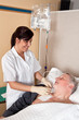 Krankenschwester gibt einem Patienten eine Infusion