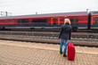 Frau wartet auf Bahnhof auf ihren Zug