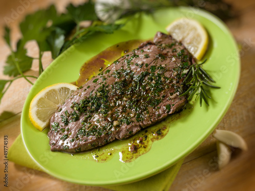 Photo: beef steack with garlic and mixed herbs, selective focus beef steack with garlic and mixed herbs, selective focus