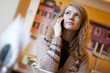 Young woman is waiting in cafe and using mobile phone