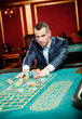 Gambler stakes piles of chips at the roulette table